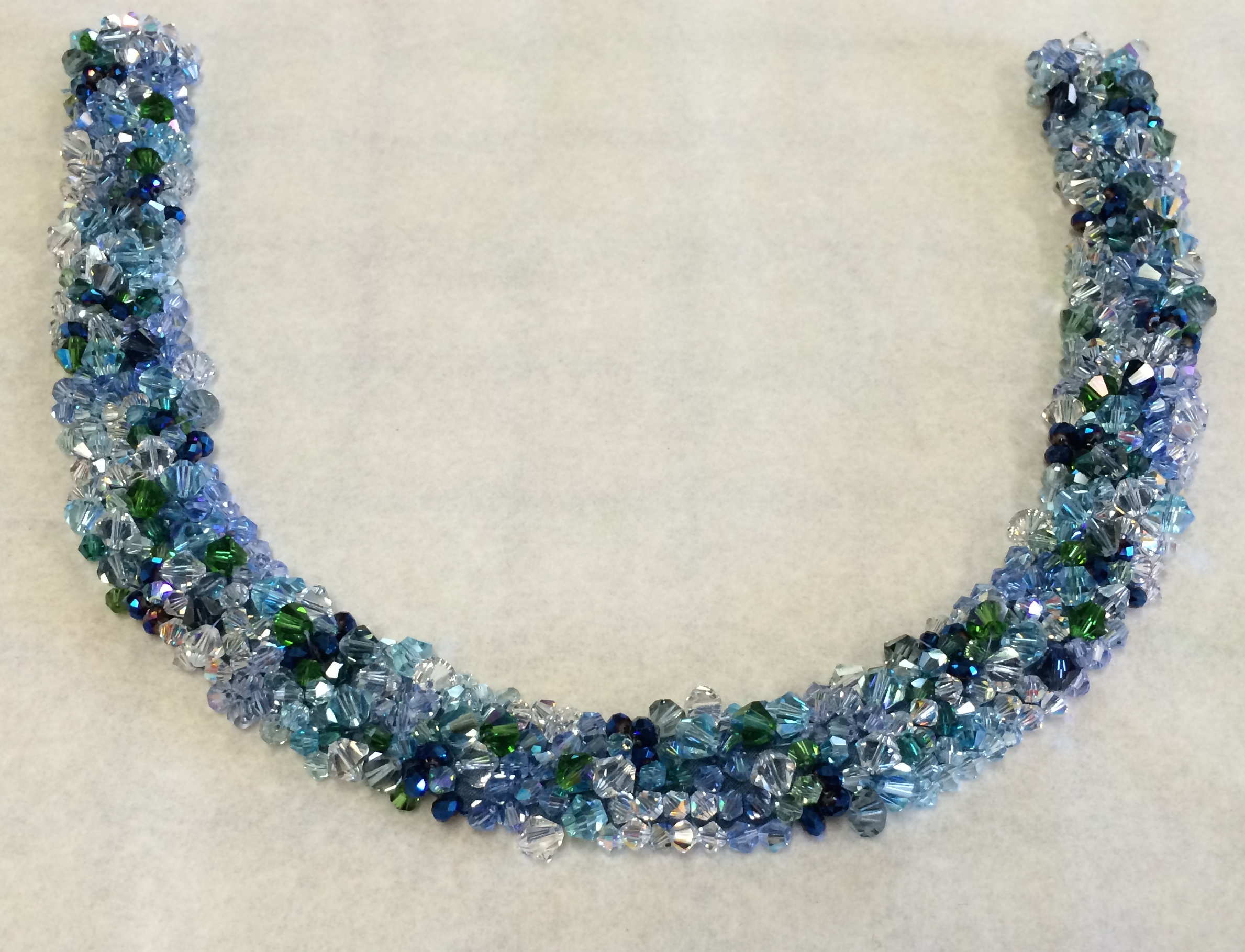 Hand-beaded crystal neckline in sea greens and blues